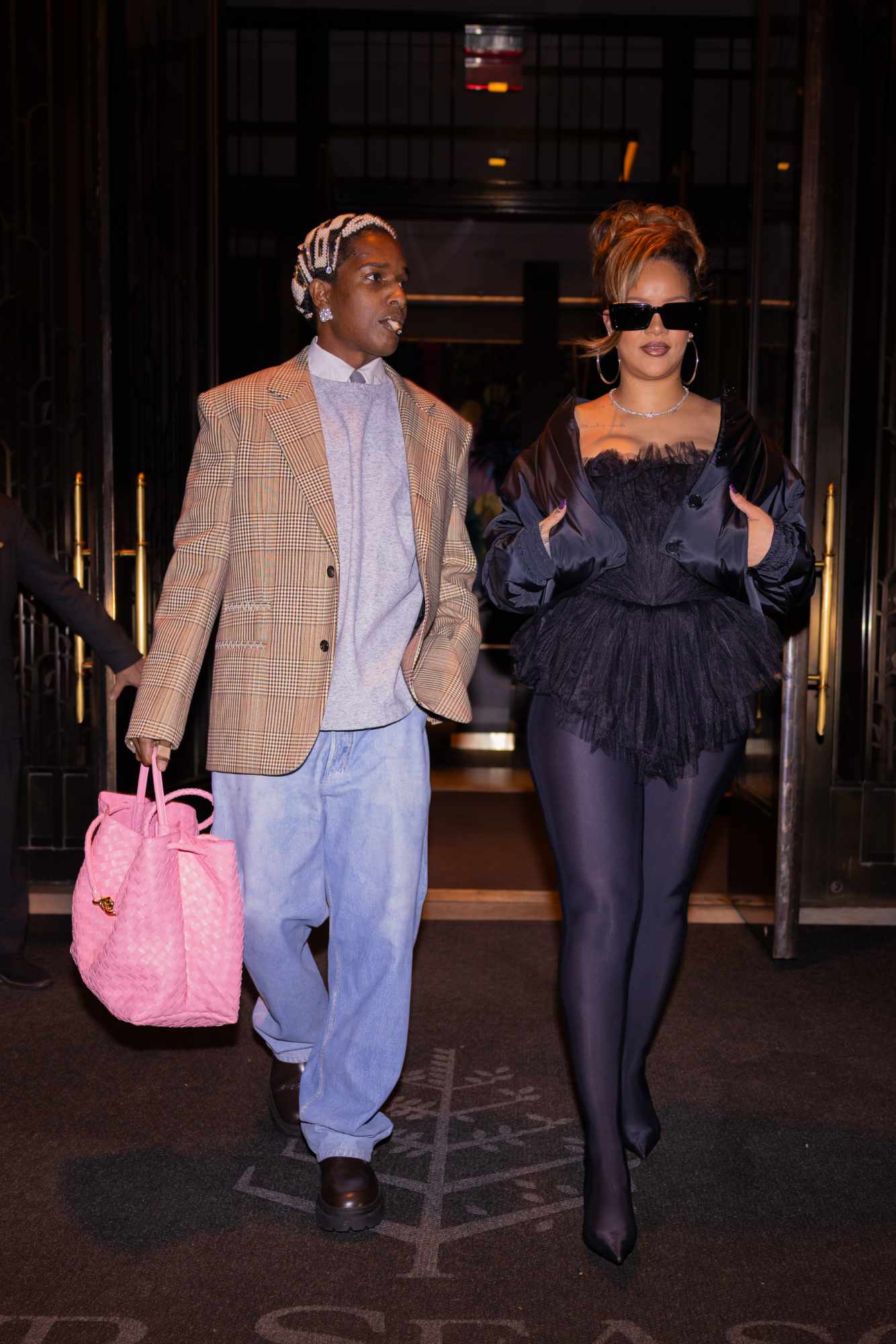 A$AP Rocky & Rihanna are seen at night heading to celebrate Rocky's 35th birthday at Carbone. Rocky wears a beige blazer, sweater, shirt, and faded leather "jeans" from Bottega Veneta